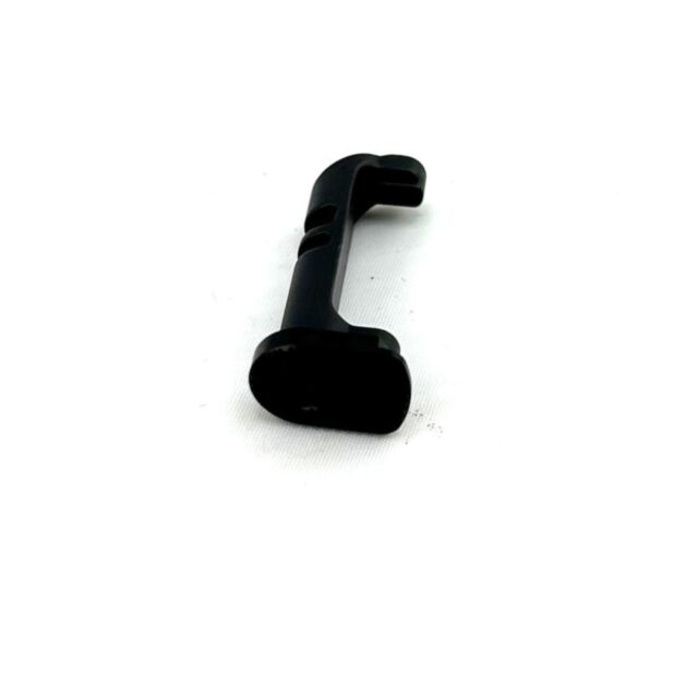 A MAGAZINE CATCH TS EXTENDED BLACK BUTTON, a small black L-shaped component with curved edges, is displayed on a plain white background.