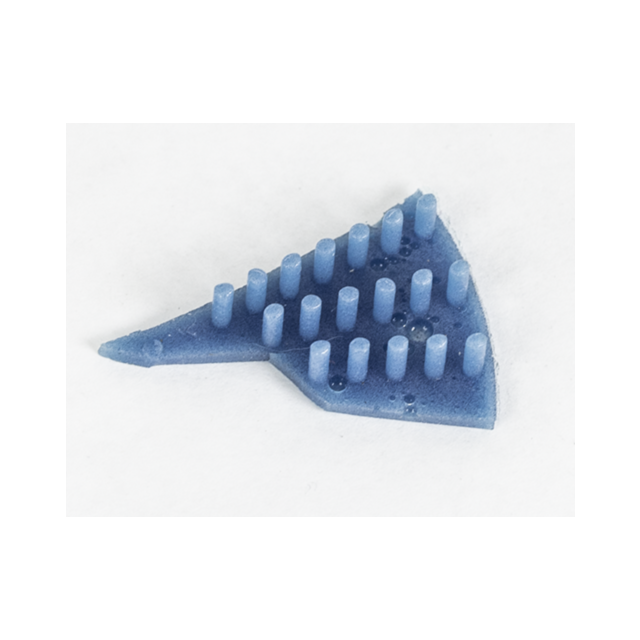 A SPRING ELEMENT BREN 2, a blue triangular 3D-printed object with multiple vertical cylindrical pegs of differing heights arranged in rows, rests on a white surface.