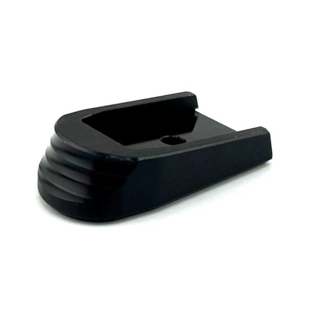 The CZUB Extended Aluminum Magazine Base for P10 is black, rectangular, with a hollow center, a rounded grooved end, and a central hole, shown on a white background.