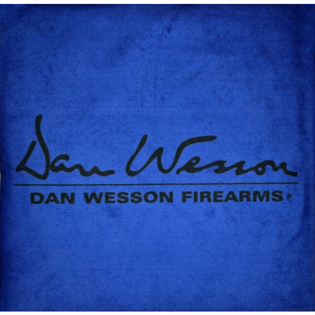 The image displays the DW logo on a BLUE MICROFIBER 16"X16" DW LOGO TOWEL. The logo showcases a stylized signature of "Dan Wesson" above the bold capitalized text "DAN WESSON FIREARMS," all set against an eye-catching blue background.