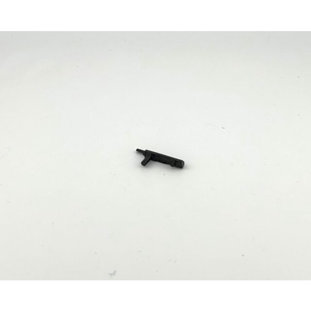 A DWX Extended Ejector, characterized by its small size, black plastic material, flat rectangular shape, and two protruding tabs, is lying on a plain white surface.