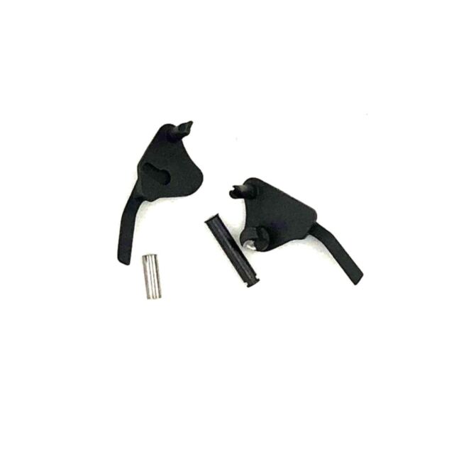 A DWX Thumb Safety Ambi Sleeve set, featuring black metal components on a white background, includes two intricately shaped pieces with protruding levers and two cylindrical pins.