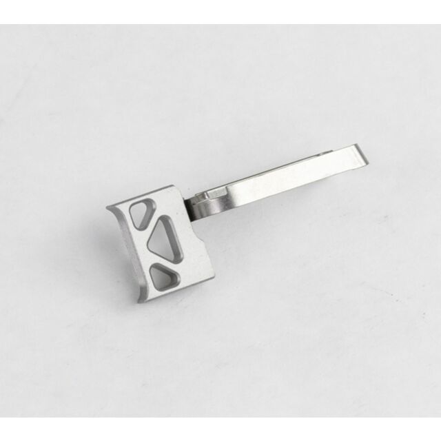The DWX FULL SIZE TRIGGER ASM in silver is a belt buckle with a geometric cutout design and a rectangular latch mechanism, showcased against a plain white background.