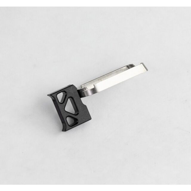 The DWX Full Size Trigger Assembly in black, featuring a geometric design and a flat silver extension, is shown on a white background.