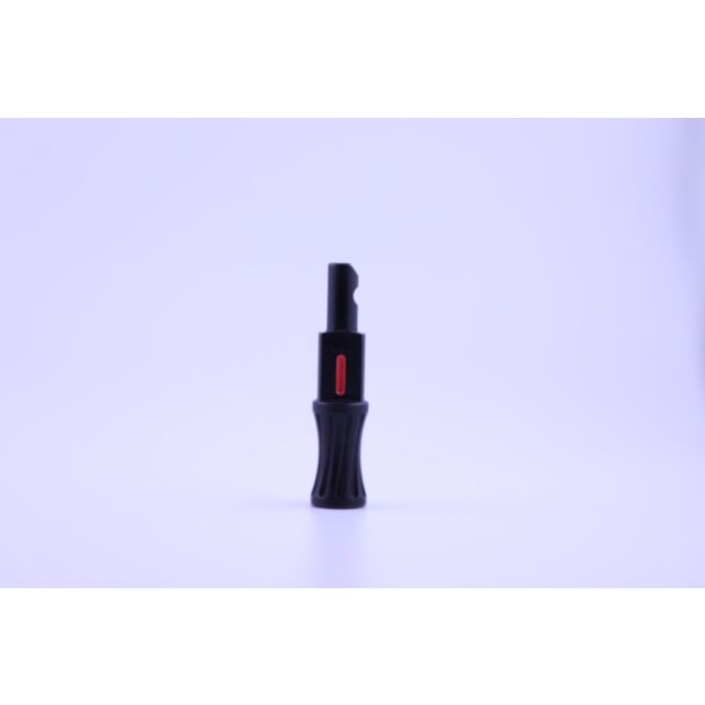The EXTENDED BOLT HANDLE 12 GA. SEMI AUTO BLACK, a small black plastic item featuring a red button in the center, stands upright against a plain white background, resembling an extended bolt handle for a 12-gauge semi-automatic shotgun.