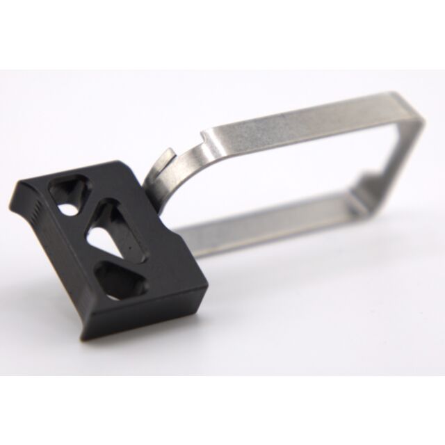 A DWX COMPACT TRIGGER ASM with a black finish featuring triangular cutouts, set on a plain white background.